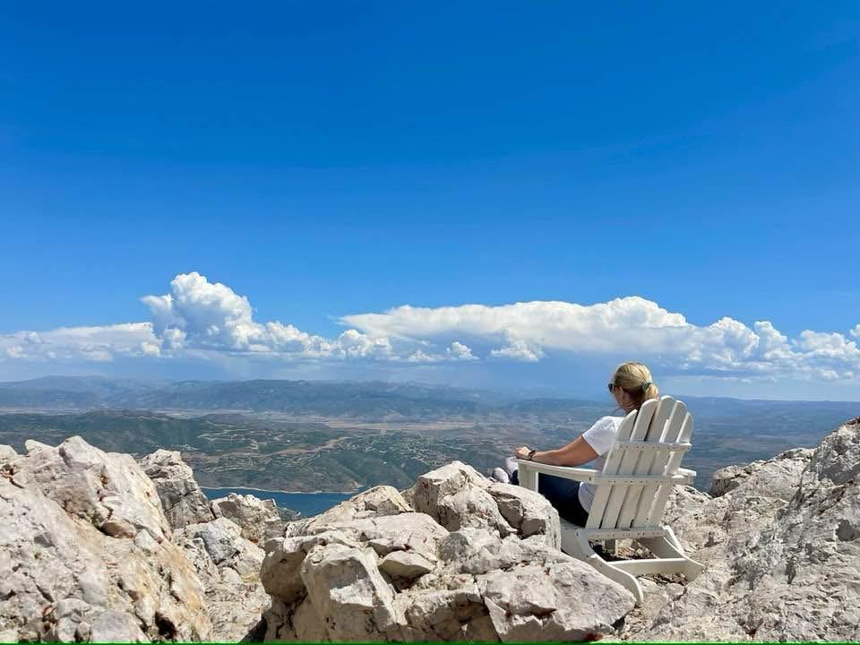 Marilyn Sherman sitting in an Adirondack chair overlooking the mountains in Park City, Utah, during a season of grief and healing